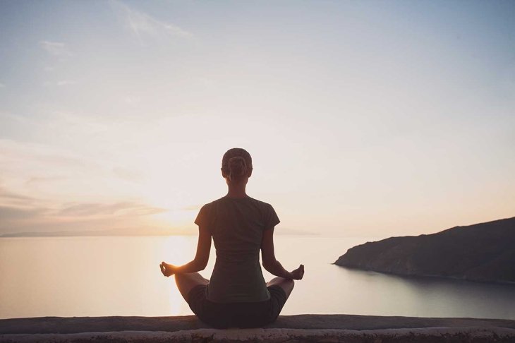 Young woman practicing yoga outdoors. Harmony and meditation concept. Healthy lifestyle