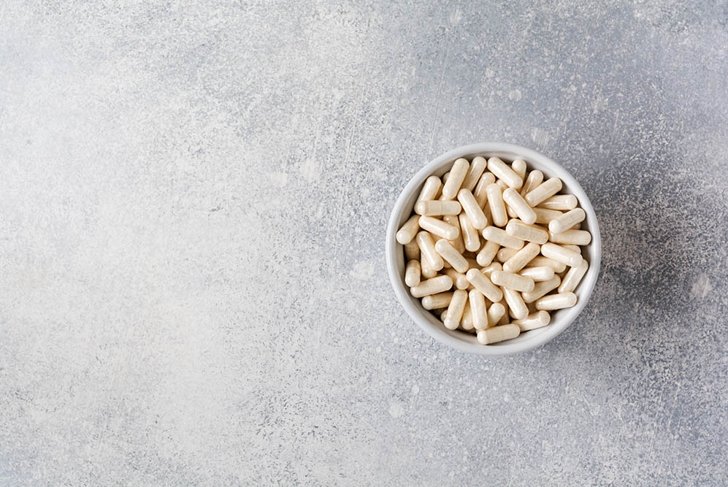 Collagen pills on gray concrete background. Healthy lifestyle concept. Copy space