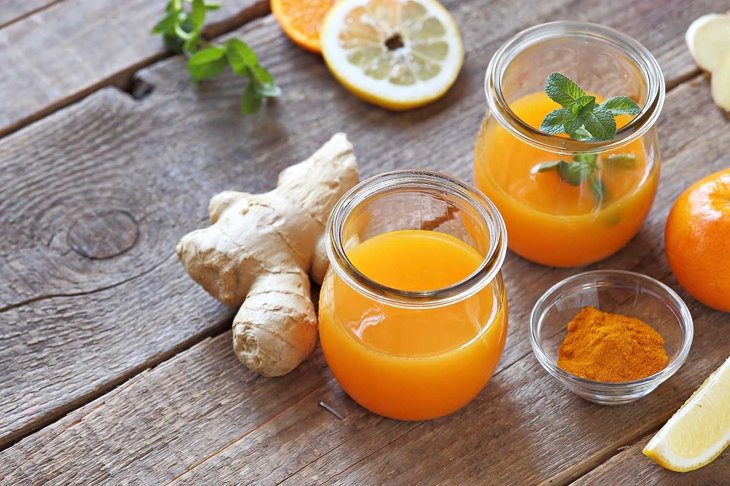 Power drink from citrus juice with ginger, turmeric and honey. Selective focus