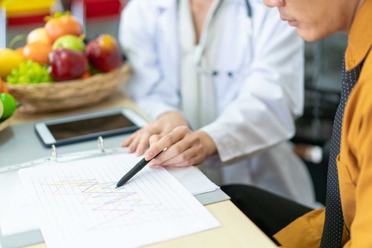 Young Asian man come to meet the nutritionist in hospital and talking about dieting and eating. Expertise nutritionist giving a eating recommendation to a man who have health problem.